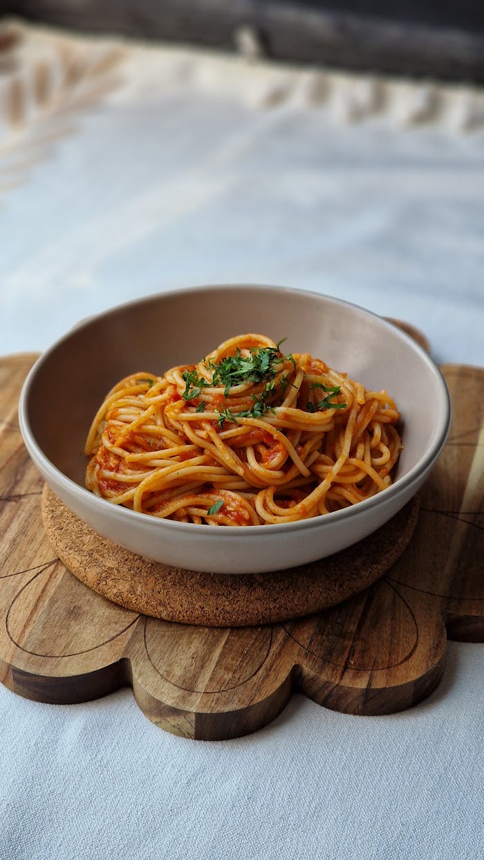 Elegant presentation of spaghetti Bolognese garnished with herbs in a simple setting.